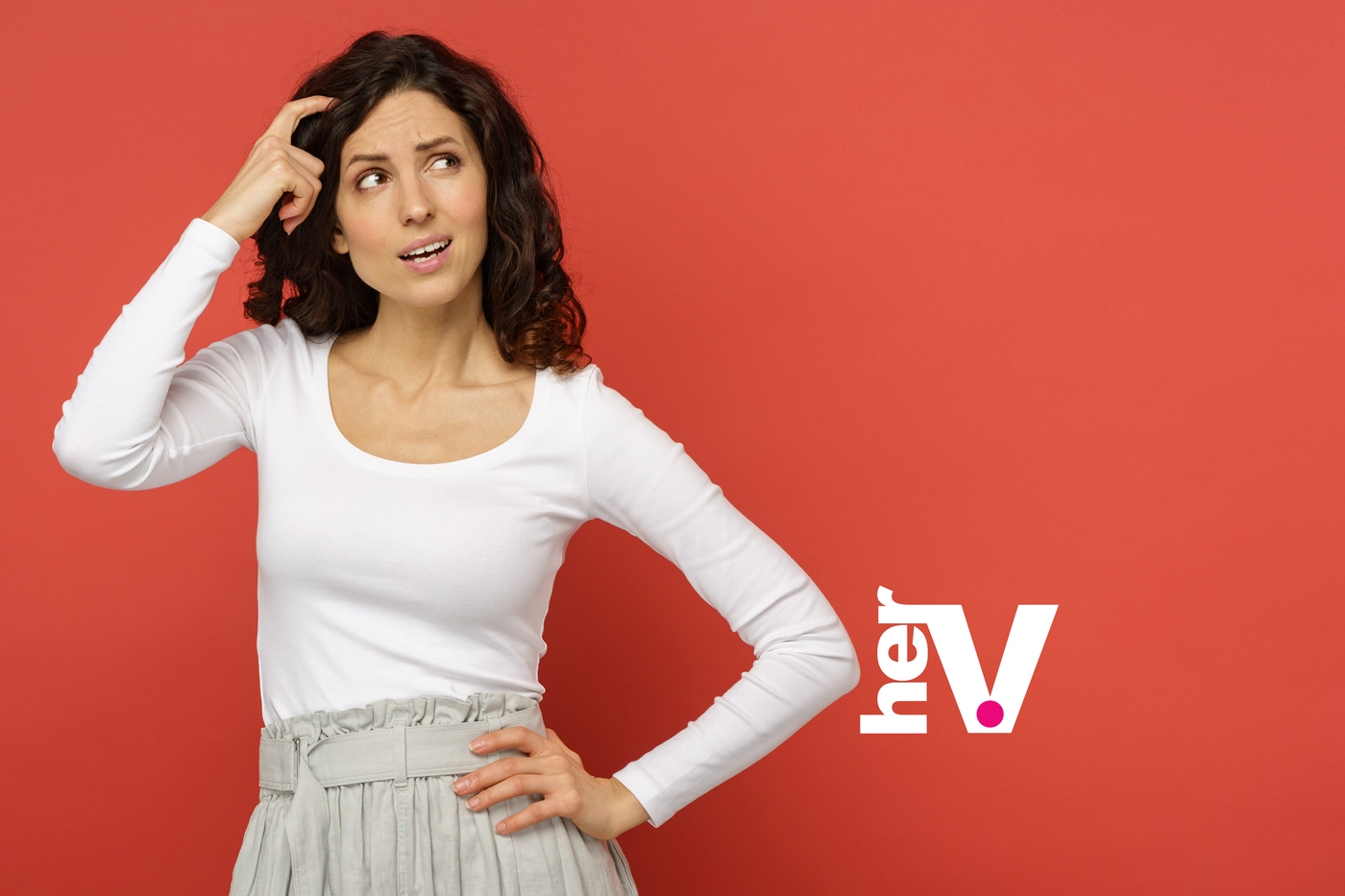 Thoughtful woman against a coral background for a spit or swallow sex tips article image