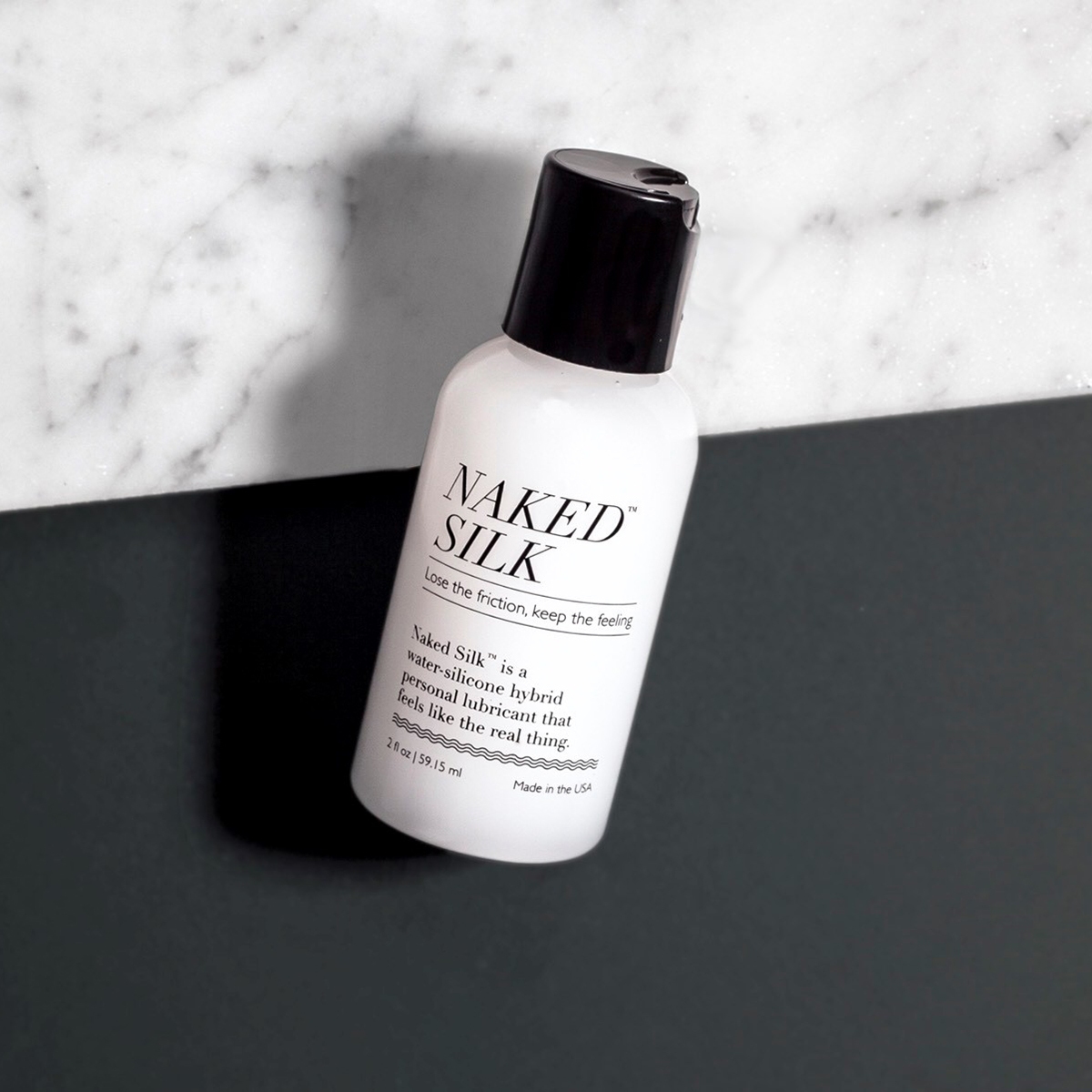 Bottle of 2 oz Hybrid Lube Naked Silk showing water-silicone fusion formula